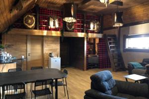 a living room with a table and chairs and a kitchen at Hunter's Lodge in (( Šarlote ))