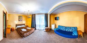 sala de estar con sofá y cama en Rostovchanka resort inn, en Lazarevskoye