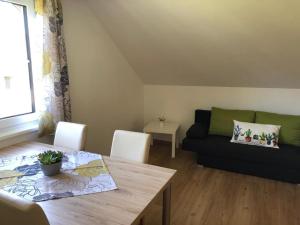 a living room with a table and a couch at Alpine Appartments Ausseerland in Bad Aussee