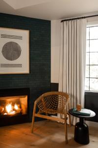 a living room with a chair and a fireplace at San Luis Creek Lodge in San Luis Obispo