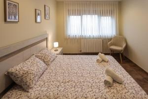 a bedroom with a bed with two pairs of shoes on it at Apartamentos el Proel in Pedreña