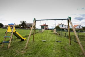 an empty playground with swings and a slide at Apartamentos el Proel in Pedreña