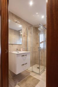 La salle de bains est pourvue d'un lavabo et d'une douche. dans l'établissement Apartamentos el Proel, à Pedreña
