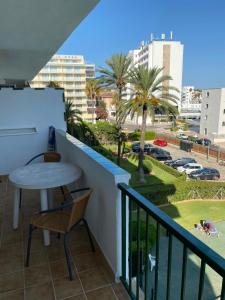 Apartment Alcudia Beach في بورت ذالكوذيا: بلكونه مع طاوله وكراسي واطلاله على مدينه