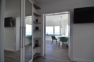 Zimmer mit einem Spiegel und einem Esszimmer mit einem Tisch in der Unterkunft Schipperhus in Timmendorfer Strand