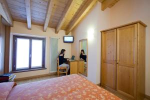 two women sitting at a desk in a bedroom at Hotel Ferrari in Castione della Presolana