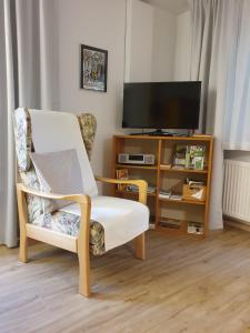 a living room with a chair and a television at Ferienwohnung Sautter in Beuren