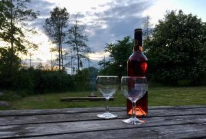 una bottiglia di vino e due bicchieri su un tavolo di legno di Korinth Kro Hostel a Faaborg