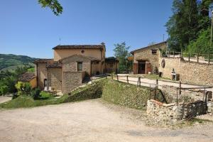 a large stone house with a fence in front of it at Country House Ca' Vernaccia in Urbino