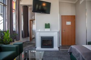 a living room with a fireplace and a tv on a wall at AUSZEIT DAS HOTEL Schweitenkirchen in Schweitenkirchen