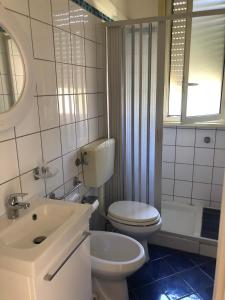 a bathroom with a toilet and a sink and a tub at Appartamentino in villa sul mare in Noto Marina