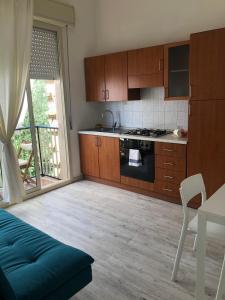 a kitchen with wooden cabinets and a stove top oven at Appartamentino in villa sul mare in Noto Marina