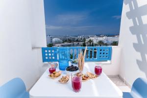 - une table avec des pâtisseries et des boissons sur un balcon dans l'établissement Les Deux Rives, à Hammamet Sud