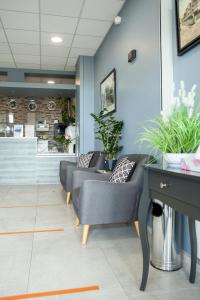 poczekalnia z kanapami, stołem i roślinami w obiekcie Hotel Les Galets w mieście Criel-sur-Mer