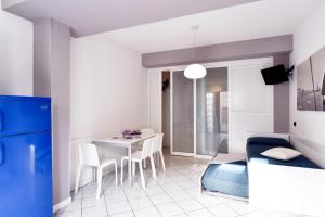 sala de estar con mesa y sofá azul en Hotel & Residence Progresso, en Lido di Jesolo
