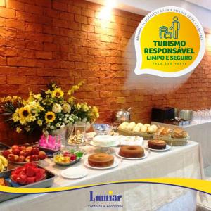 a table with a buffet of food on it at Hotel Lumiar in Coronel Fabriciano