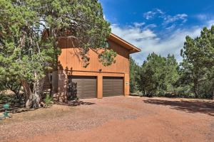 a house with a garage with a tree at Romantic Sedona Suite with Patio Less Than 1 Mi to Trails in Sedona