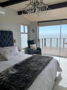 a bedroom with a large bed with a view of the ocean at Lalapanzi in Fish Hoek
