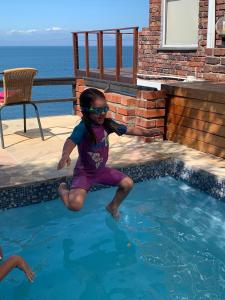 a little girl jumping into a swimming pool at Lalapanzi in Fish hoek