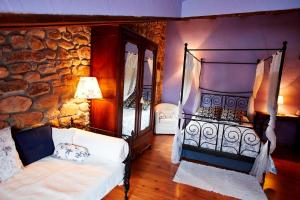 a bedroom with a bed and a stone wall at Posada Rural Ochohermanas in Las Fraguas