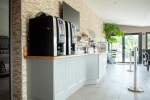 - une cuisine avec deux fours micro-ondes installés sur un comptoir dans l'établissement Hotel Les Galets, à Criel-sur-Mer