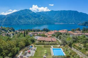 eine Luftansicht eines Resorts mit See und Bergen in der Unterkunft Apartment Gli Ulivi - Tremezzina in Tremezzo
