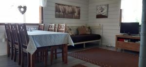 ein Esszimmer mit einem Tisch und einem TV in der Unterkunft Topin Tupa 1 in Oravisalo