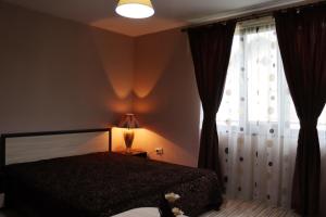 a bedroom with a bed and a large window at GREEN HOUSE - Попниколови in Sapareva Banya