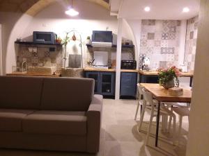 een woonkamer met een bank en een tafel in een keuken bij POZZO FIORITO in Matera