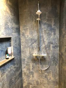 a shower in a bathroom with a concrete wall at Het Huis van de Wadden in Den Oever +63 photos