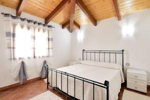 オルメードにあるSa Mandracchinaの木製の天井が特徴のベッドルーム1室(ベッド1台付)