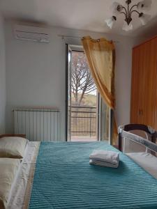 1 dormitorio con cama y ventana grande en Appartamenti Brufa Civico 13/17, en Brufa