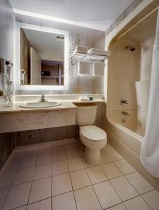a white toilet sitting next to a bath tub in a bathroom at Monte Carlo Inn Markham in Markham