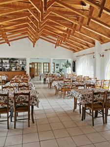 d'une salle à manger avec des tables et des chaises et des plafonds en bois. dans l'établissement Cseri Kastélyszálló, à Tótvázsony