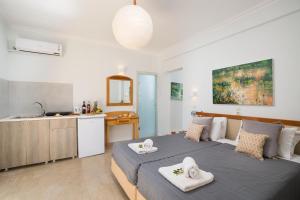 a bedroom with a large bed and a kitchen at Finata Studios in Kavos