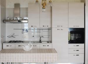 a kitchen with white cabinets and a sink at Villa Largo Belvedere in Campomarino