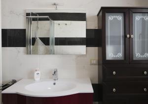 a bathroom with a sink and a black cabinet at Villa Largo Belvedere in Campomarino