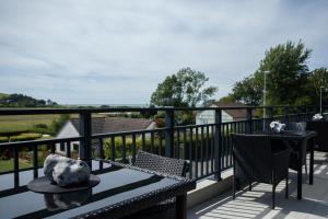 a patio with a table and chairs on a balcony at Hotel Les Galets in Criel-sur-Mer
