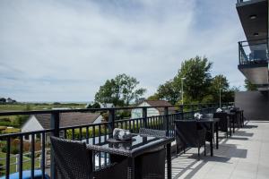 a patio with tables and chairs on a balcony at Hotel Les Galets in Criel-sur-Mer +47 photos