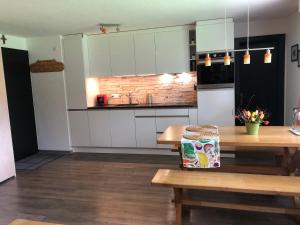 a kitchen with white cabinets and a wooden table at Cresta di Saas in Saas-Grund