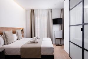 ein Hotelzimmer mit einem großen Bett und einem Fenster in der Unterkunft VIL5 by Be Alicante in Alicante
