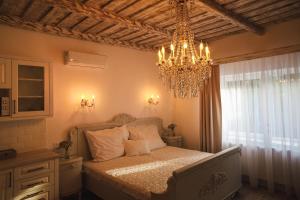 a bedroom with a bed and a chandelier at BAB-LAK Apartman in Kisvárda