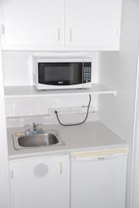 a kitchen with a sink and a microwave at Harbourview Motel and Accommodations in Port Hawkesbury