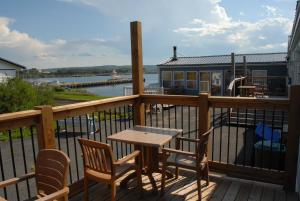 une terrasse en bois avec une table et des chaises ainsi qu'une maison dans l'établissement Harbourview Motel and Accommodations, à Port Hawkesbury