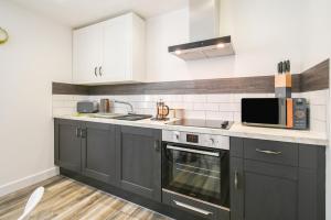 a kitchen with black cabinets and a microwave at Woodland View in York