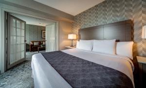a hotel room with a large bed and a large mirror at Monte Carlo Inn Markham in Markham
