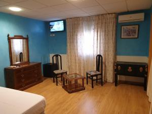 sypialnia z łóżkiem, 2 krzesłami i komodą w obiekcie Hostal Alfil w mieście Cazalegas