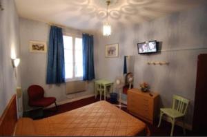 a bedroom with a bed and a window and a tv at Notre Dame AUXILIATRICE in Lourdes