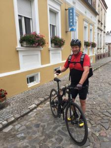 a man standing next to a bike on a street at pension & sauna AM LORENZ in Calbe