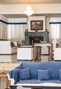 a living room with a blue couch and a fireplace at Hotel Elena in Larisa